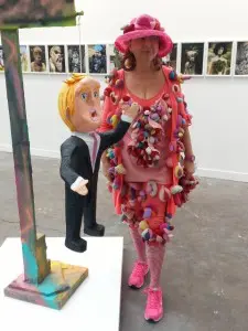 L'artiste polonaise mais vivant en Allemagne Alexandra Holownia, aka Alexandra Fly, portant l'une de ses créations, pose à côté d'un sculpture de l'artiste américaine Rachel Harrison: "Dulce de leche" (2015) présentée par la galerie Greene Naftali. L'oeuvre, sorte de pinata, valant comme effigie de Donald Trump... langue bien pendue...(techniques mixtes: ciment, bois, papier mâché peint). 